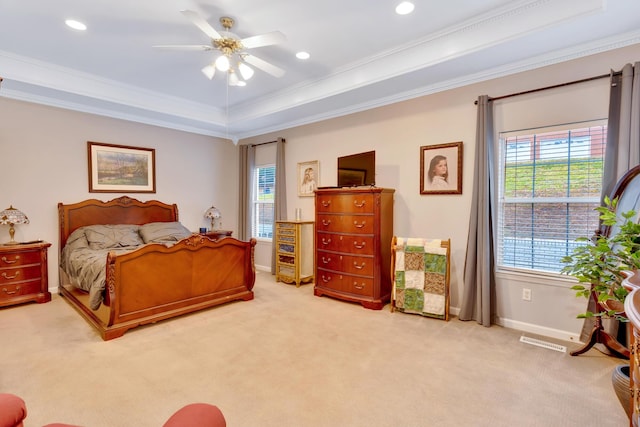 bedroom featuring a raised ceiling, crown molding, light carpet, and ceiling fan