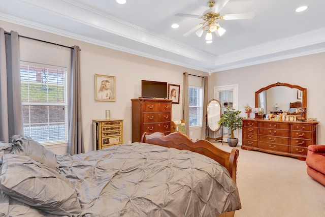 bedroom with carpet floors, ornamental molding, a raised ceiling, and ceiling fan