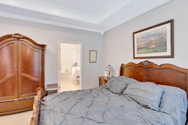 bedroom featuring crown molding, ensuite bath, and a tray ceiling