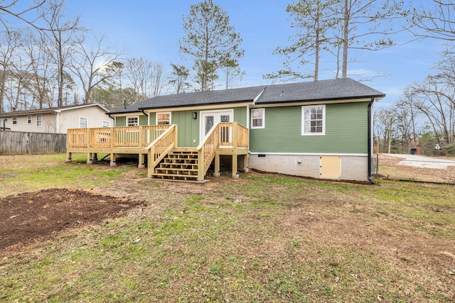 rear view of house featuring a deck and a lawn