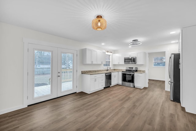 kitchen featuring french doors, sink, light hardwood / wood-style flooring, appliances with stainless steel finishes, and white cabinets