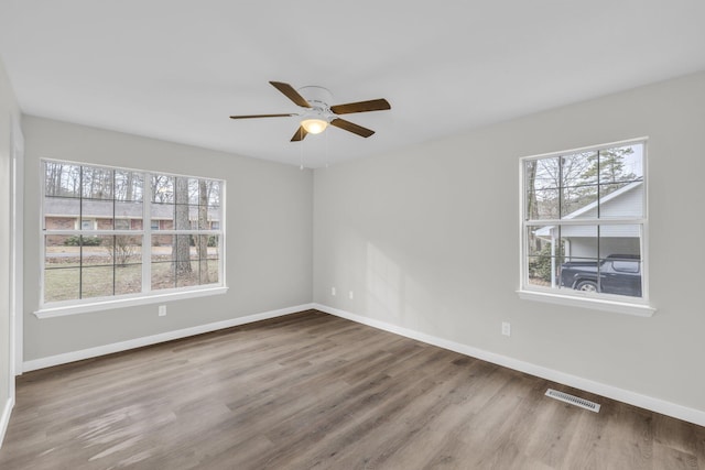 unfurnished room featuring hardwood / wood-style flooring, ceiling fan, and a wealth of natural light