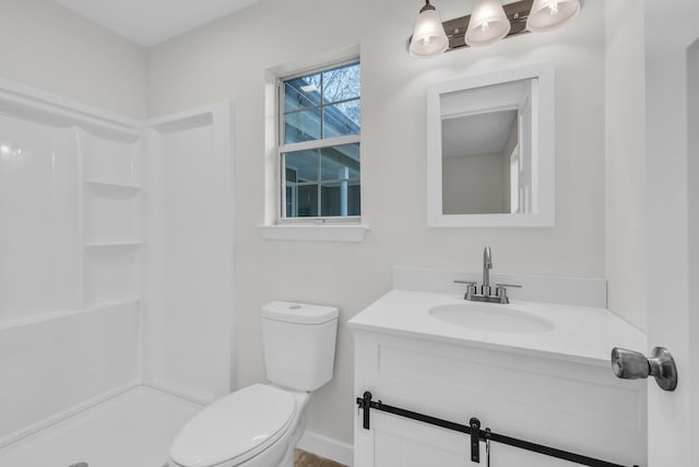 bathroom with vanity, toilet, and a shower