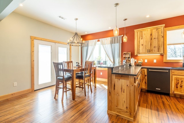 kitchen featuring dark hardwood / wood-style flooring, hanging light fixtures, stainless steel dishwasher, and a chandelier