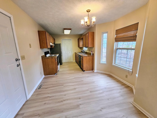 kitchen with sink, a textured ceiling, light hardwood / wood-style flooring, a notable chandelier, and white range with electric cooktop