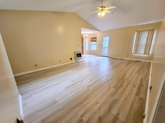 unfurnished living room featuring ceiling fan with notable chandelier, lofted ceiling, light hardwood / wood-style floors, and heating unit