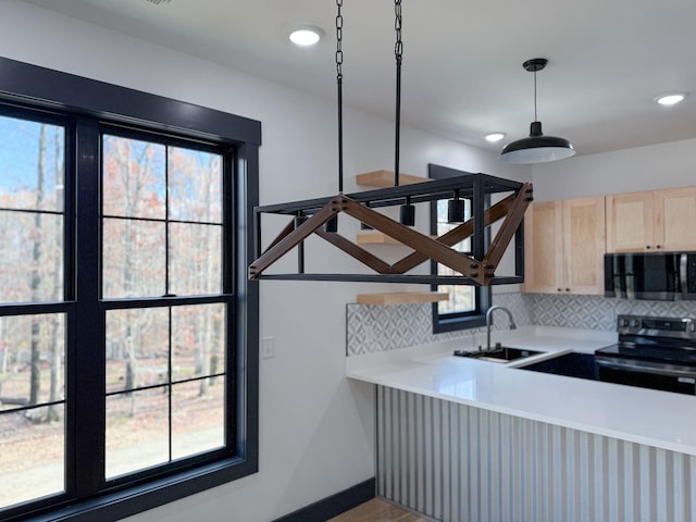 room details with appliances with stainless steel finishes, light brown cabinetry, sink, decorative backsplash, and hanging light fixtures