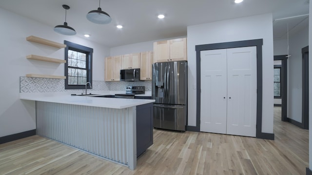 kitchen with sink, hanging light fixtures, black fridge with ice dispenser, kitchen peninsula, and stainless steel electric range