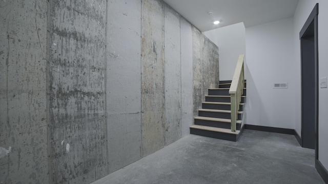 stairs featuring concrete flooring