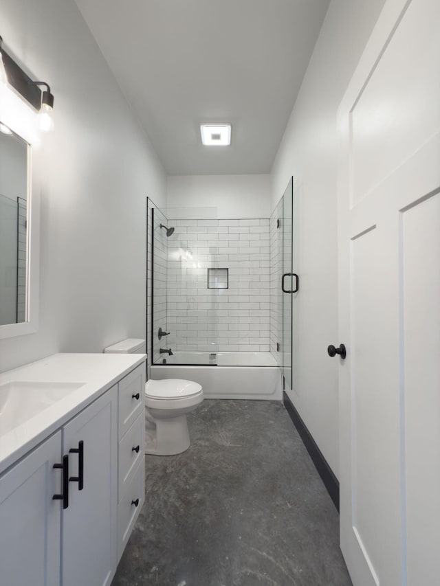 full bathroom featuring tiled shower / bath, vanity, and toilet