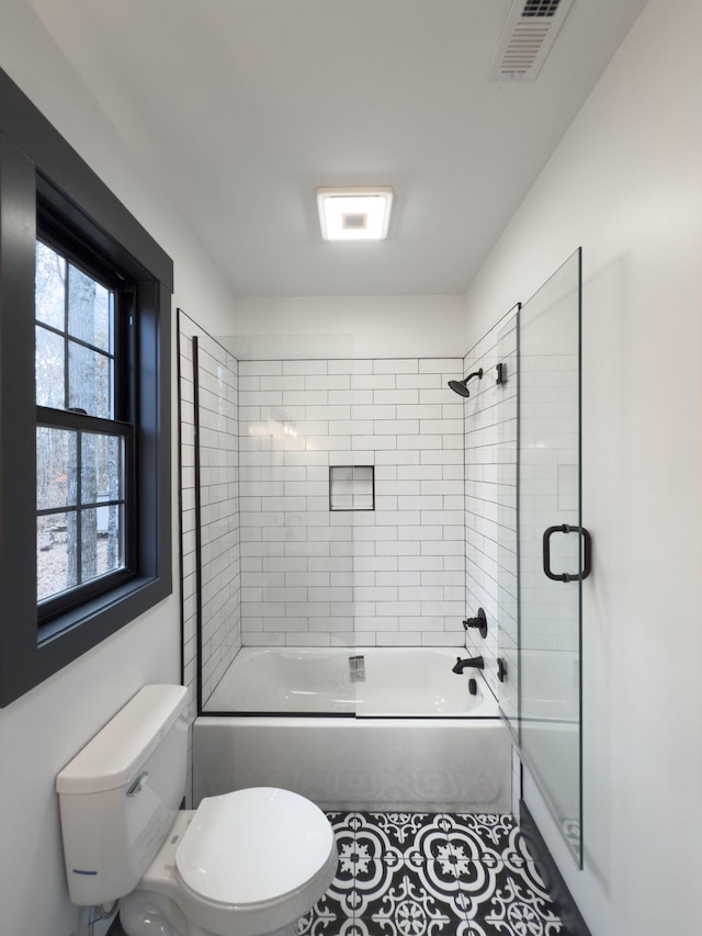 bathroom featuring bath / shower combo with glass door and toilet