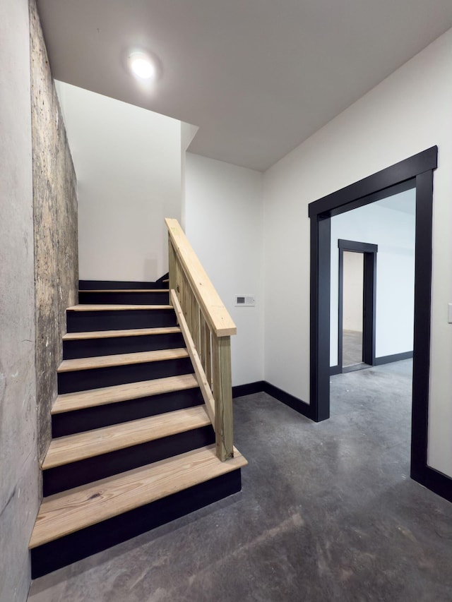 staircase featuring concrete flooring