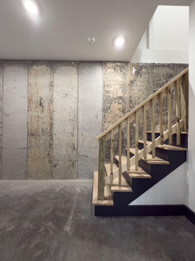 stairs with concrete flooring