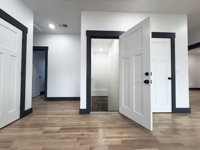 corridor with light hardwood / wood-style flooring