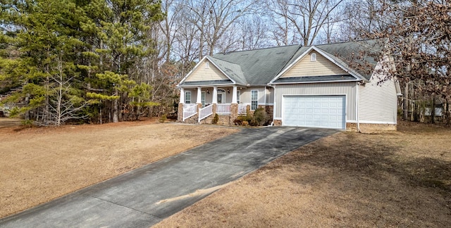 view of front of home with a garage, a front lawn, and covered porch