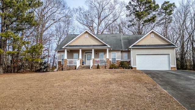 craftsman-style house featuring a garage, a porch, and a front lawn