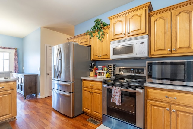 kitchen featuring dark hardwood / wood-style floors and appliances with stainless steel finishes