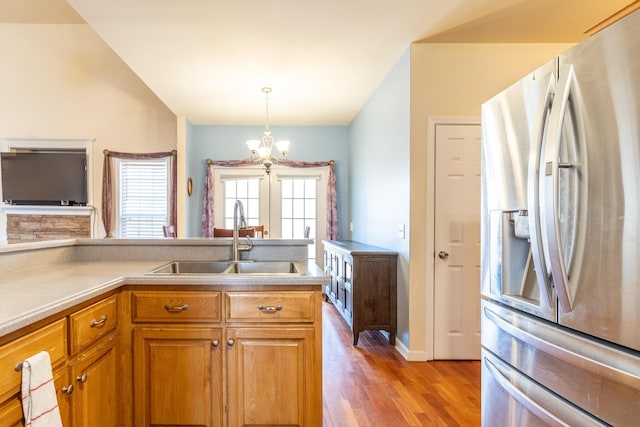 kitchen featuring decorative light fixtures, sink, a chandelier, light hardwood / wood-style floors, and stainless steel refrigerator with ice dispenser