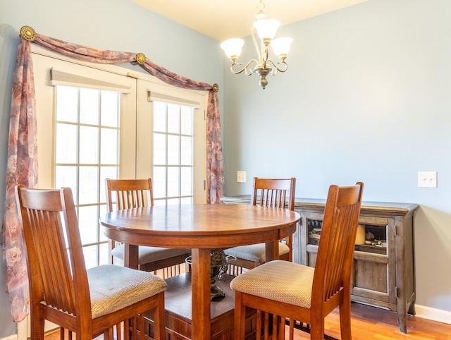 dining space with an inviting chandelier and light hardwood / wood-style flooring