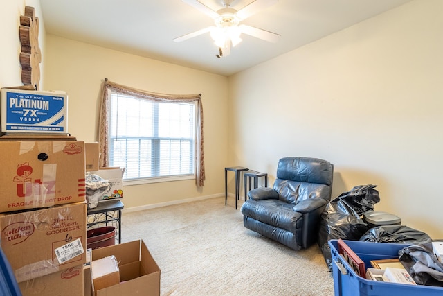 sitting room with ceiling fan and carpet