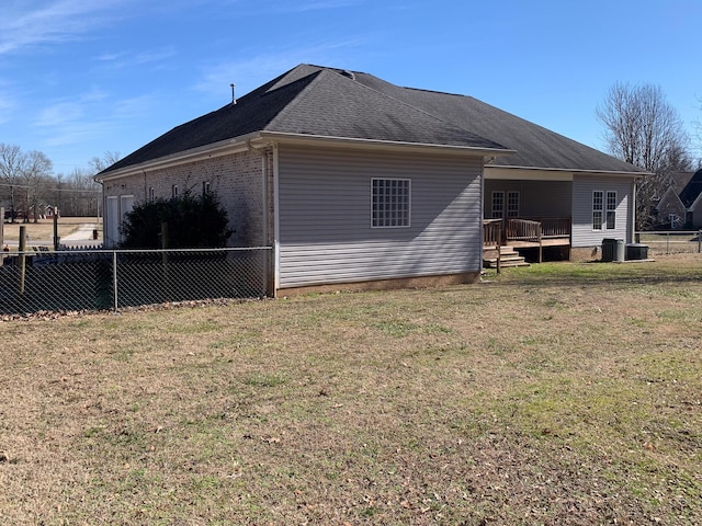 view of side of home with a yard and a deck