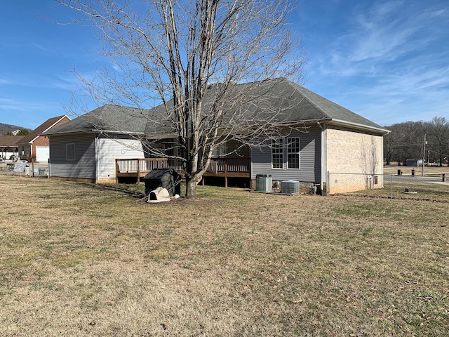 rear view of property with a wooden deck, central AC, and a lawn