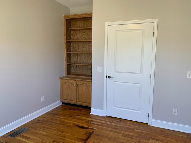 unfurnished bedroom featuring dark hardwood / wood-style flooring