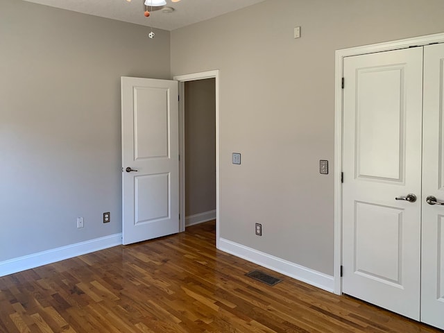 unfurnished bedroom with dark hardwood / wood-style floors and a closet