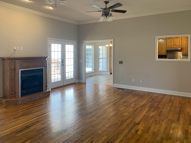 unfurnished living room featuring ornamental molding, dark wood-type flooring, ceiling fan, and french doors