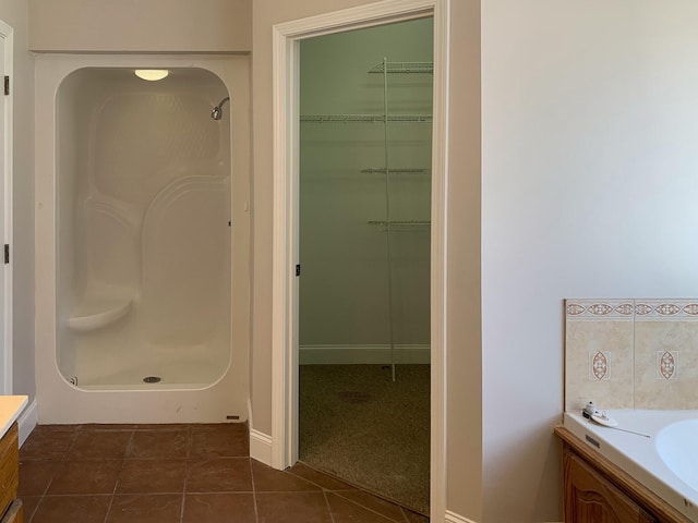 bathroom featuring walk in shower, tile patterned floors, and vanity