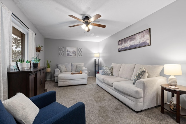 living room featuring carpet floors, a textured ceiling, and ceiling fan