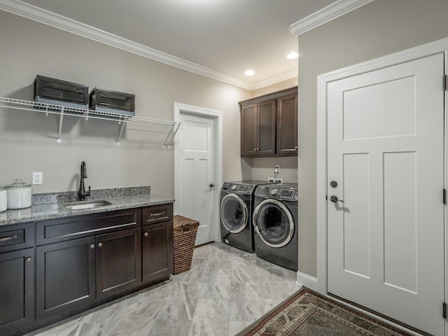 clothes washing area featuring cabinets, ornamental molding, sink, and washer and clothes dryer