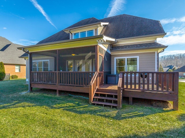 rear view of property with a sunroom, a yard, and a deck