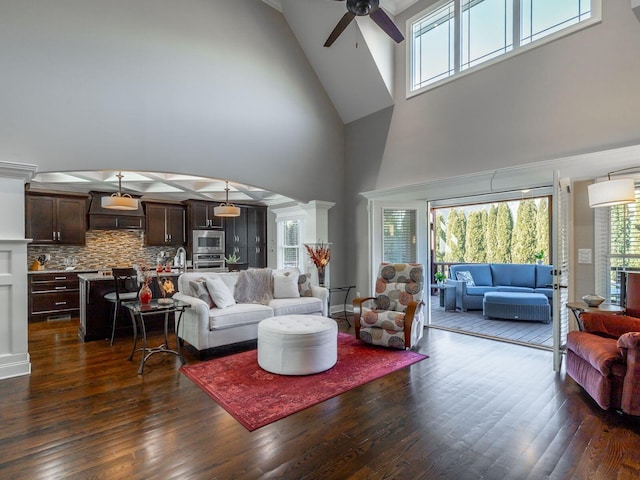 living room featuring dark hardwood / wood-style flooring, sink, ceiling fan, and ornate columns