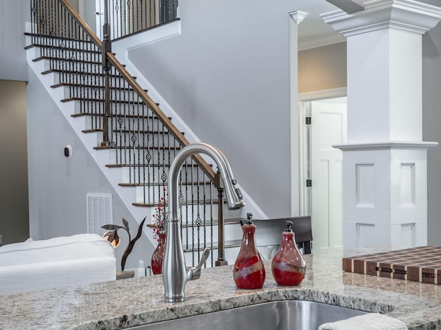 stairs with crown molding, a towering ceiling, and sink