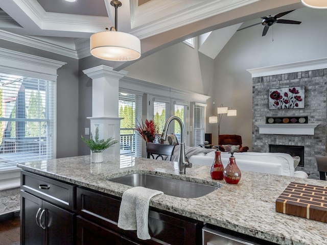 kitchen featuring hanging light fixtures, plenty of natural light, ornamental molding, and sink