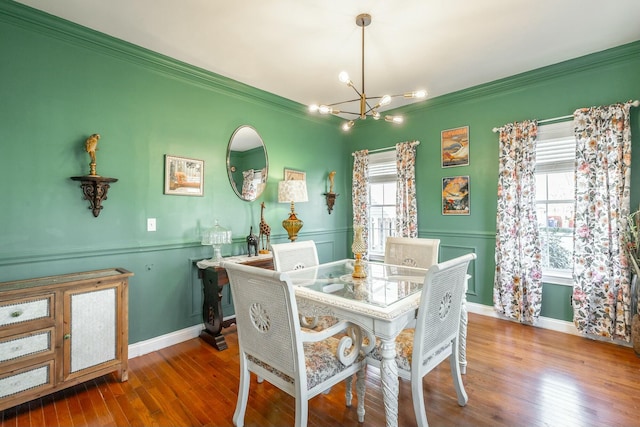 dining space featuring crown molding, hardwood / wood-style floors, and an inviting chandelier