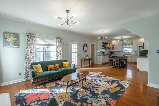 living room with ornamental molding, dark hardwood / wood-style floors, and a notable chandelier