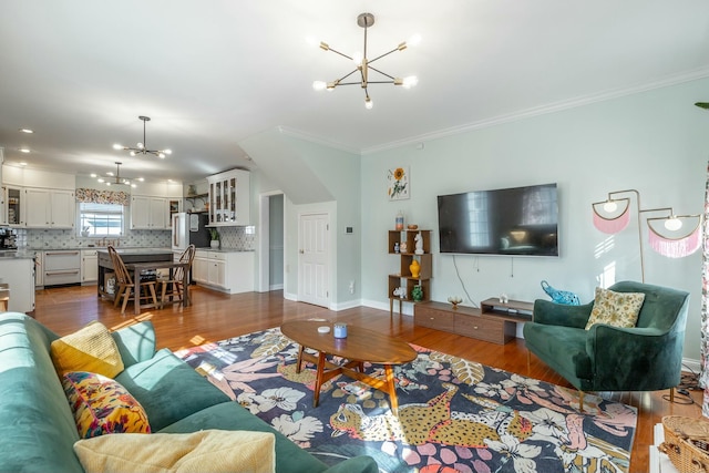 living room with dark hardwood / wood-style flooring, crown molding, and an inviting chandelier