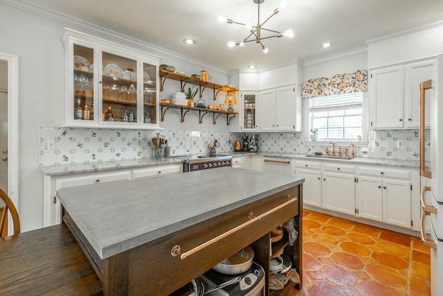 kitchen with ornamental molding, sink, white cabinets, and decorative backsplash