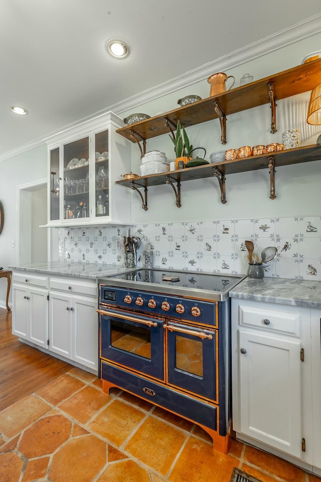 bar featuring tasteful backsplash, crown molding, range with two ovens, and white cabinets