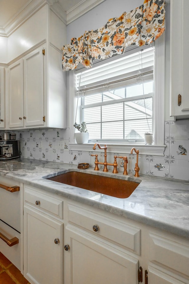 kitchen with ornamental molding, light stone countertops, sink, and decorative backsplash