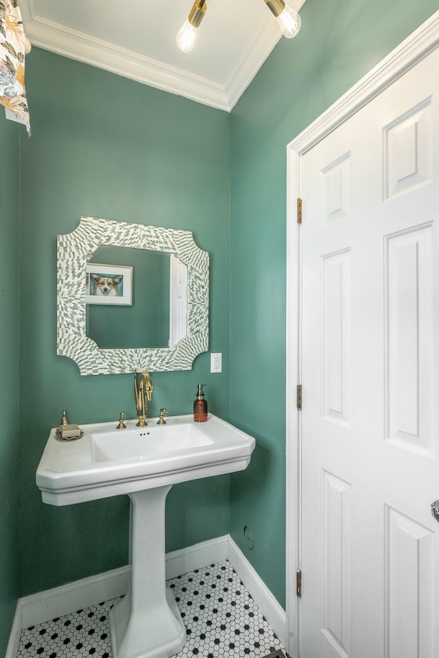 bathroom featuring tile patterned flooring, crown molding, and sink