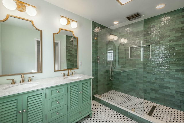 bathroom with tile patterned flooring, vanity, and a tile shower