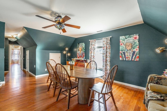 dining space featuring vaulted ceiling, ceiling fan, and hardwood / wood-style floors