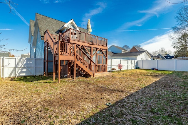 rear view of property with a lawn and a deck