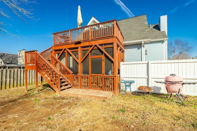 back of property with a wooden deck and a fire pit