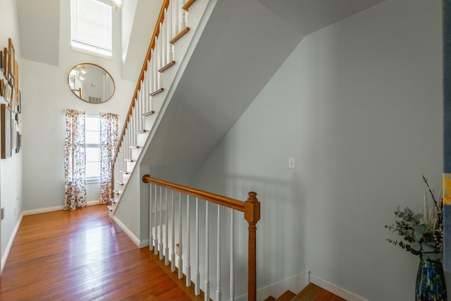 stairs with a high ceiling and wood-type flooring