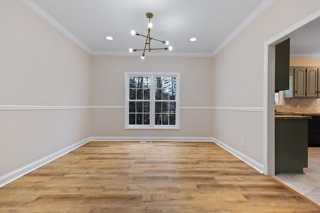 unfurnished dining area with ornamental molding, a chandelier, and light hardwood / wood-style flooring