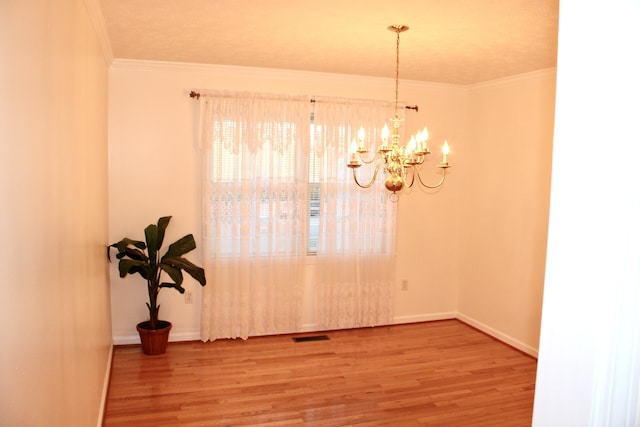 dining room with crown molding, wood-type flooring, and a chandelier